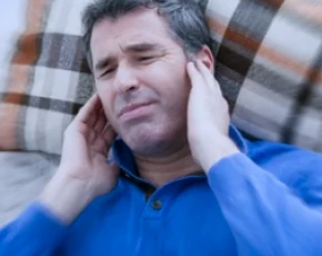 Uomo che si tocca l'orecchio, indicando dolore o disagio